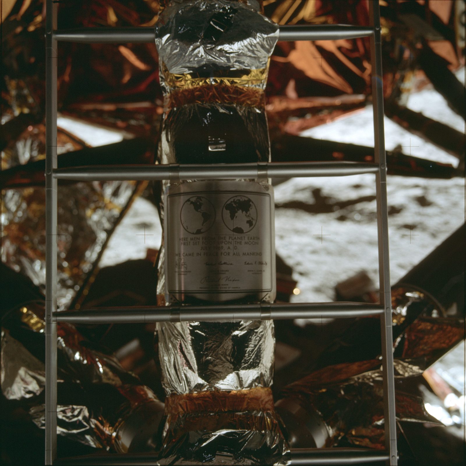 Close-up of the commemorative plaque on the LM's front landing-gear strut, behind the ladder (AS11-40-5899, NASA; the index marks this plaque sequence "Dark").