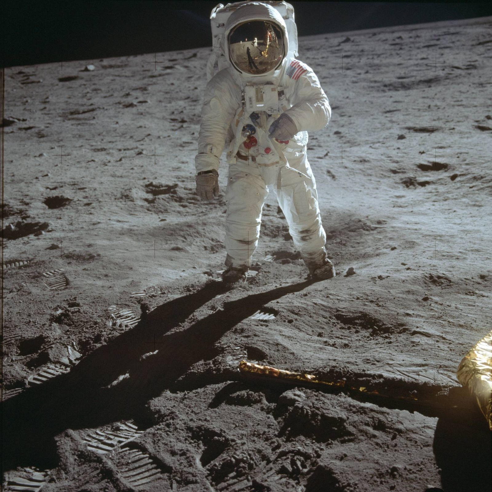 Buzz Aldrin on the surface during the first moonwalk; Neil Armstrong and the LM are reflected in his visor — the "Visor Shot" (AS11-40-5903, NASA).