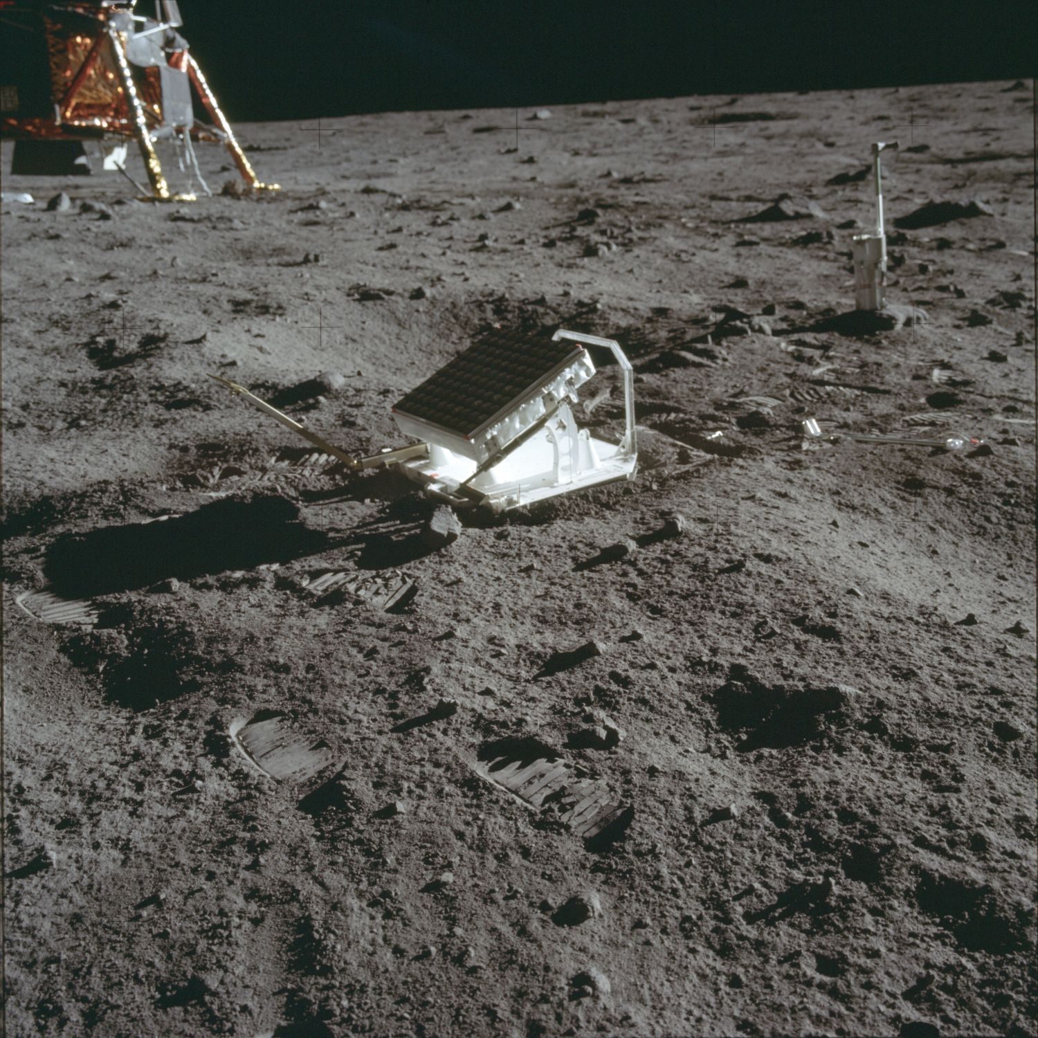 The deployed Laser Ranging Retroreflector (LRRR) at Tranquility Base, with an LM footpad and a staff nearby (AS11-40-5952, NASA).