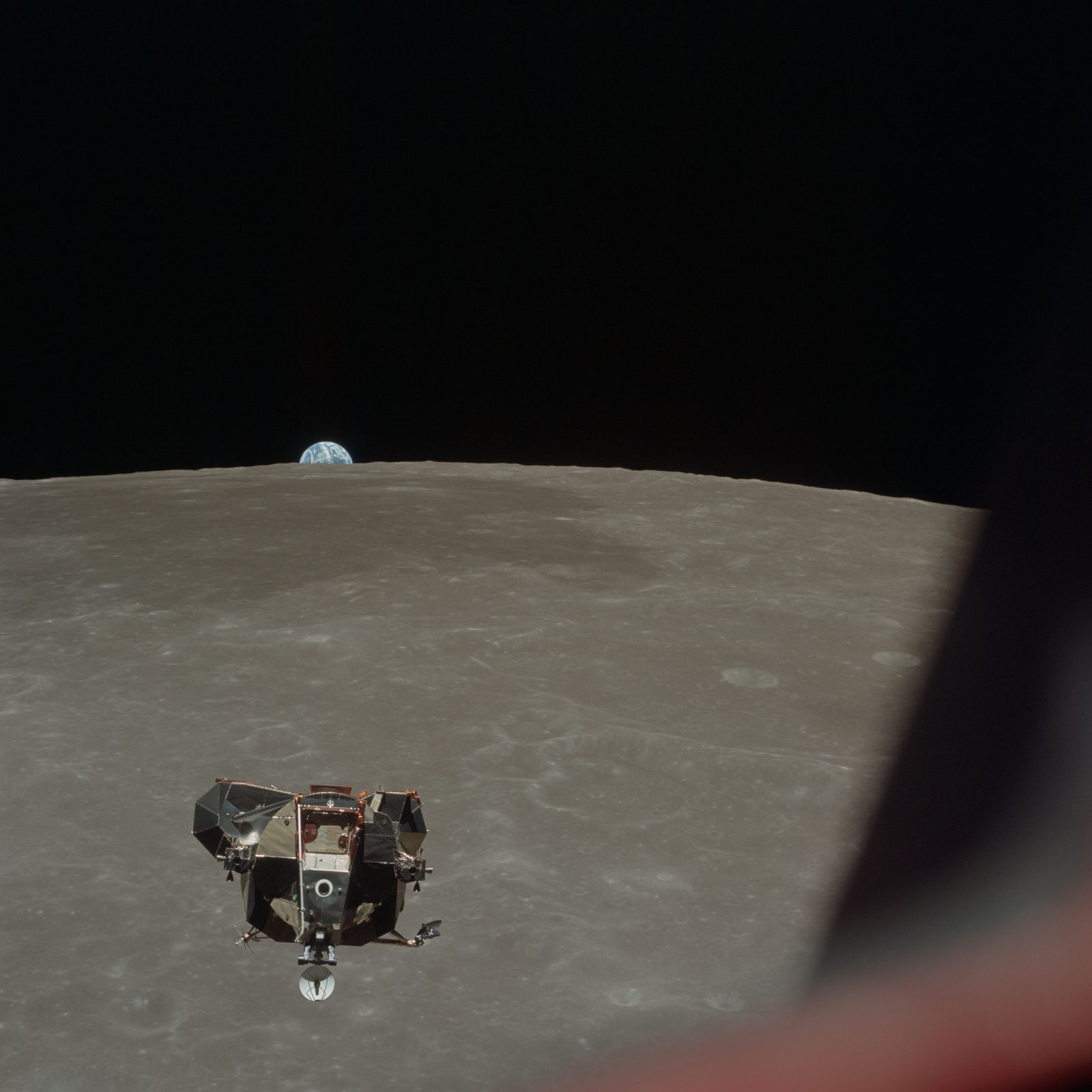 Eagle's ascent stage approaching Columbia for rendezvous, the lunar limb over Mare Smythii and the Earth on the horizon beyond (AS11-44-6634, NASA; National Archives scan).
